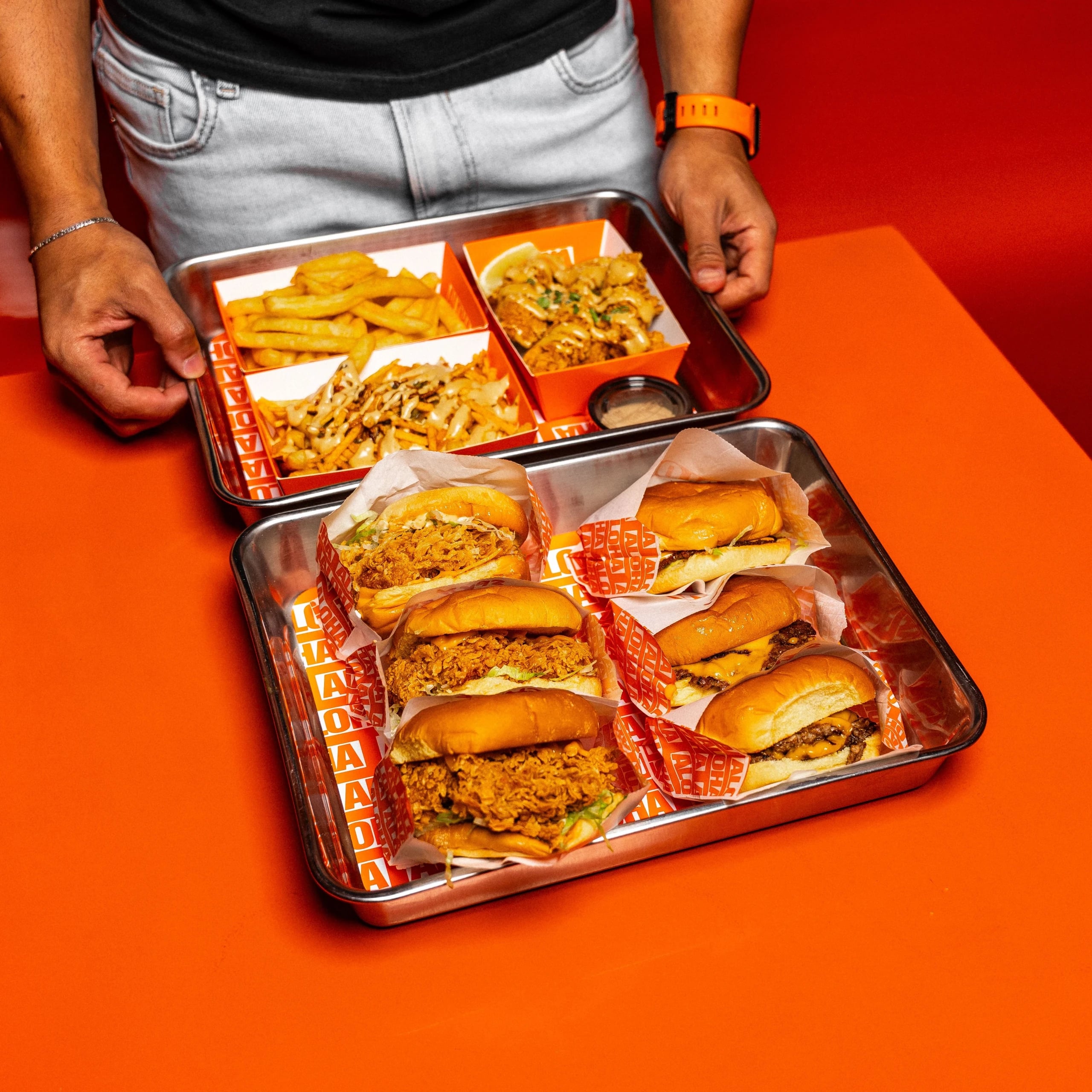 A hospitality worker carrying freshly prepared food trays