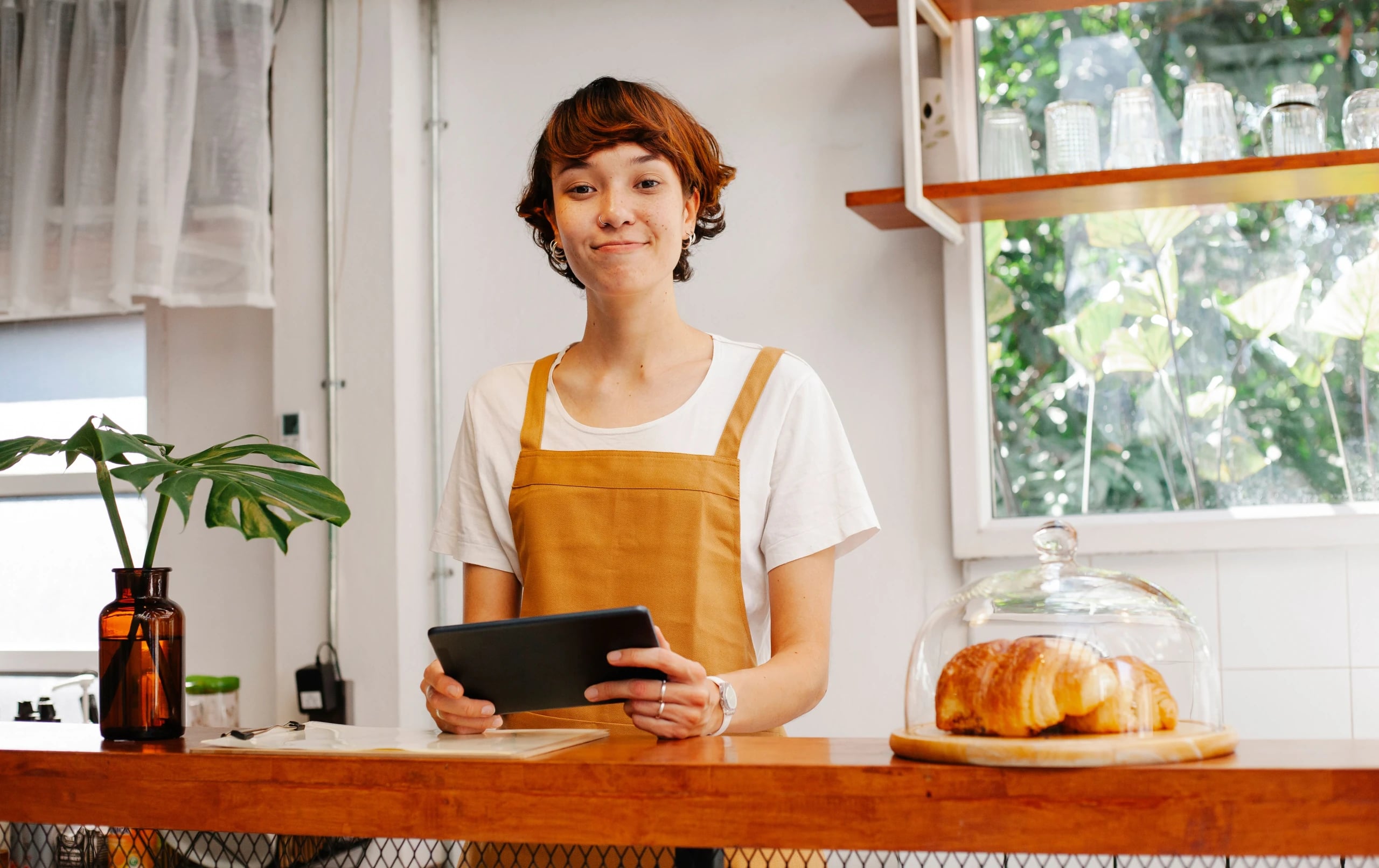 Independent cafe operator checking a tablet behind the counter